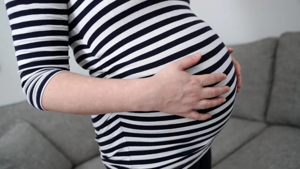 A pregnant woman holding her tummy